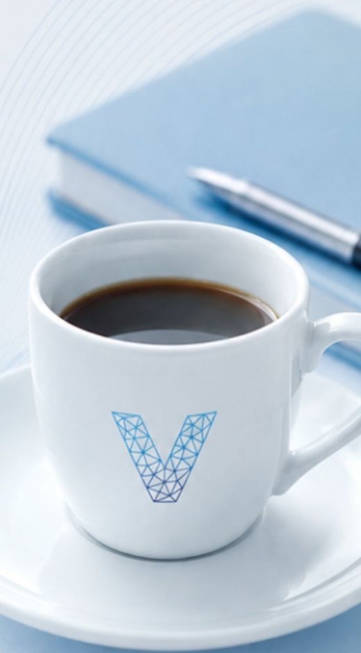 Tazzina di caffè con il logo Verum accanto a un'agenda