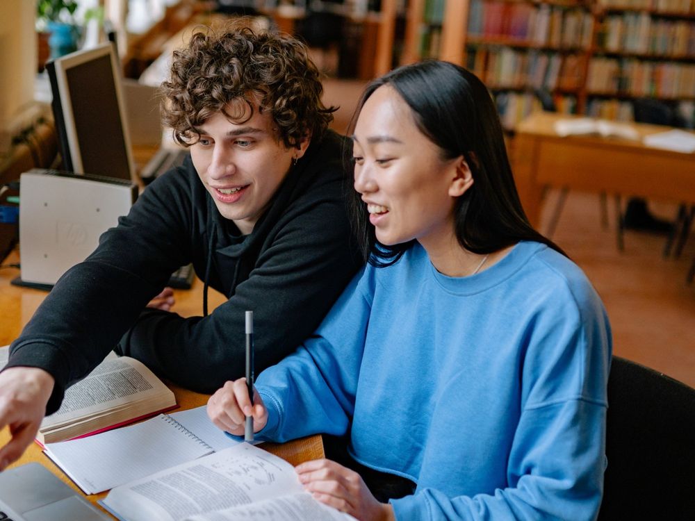 Due giovani studiano insieme in biblioteca